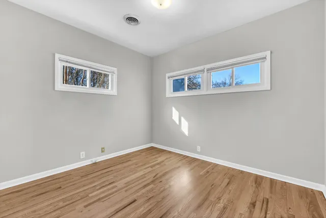 a view of empty room with wooden floor