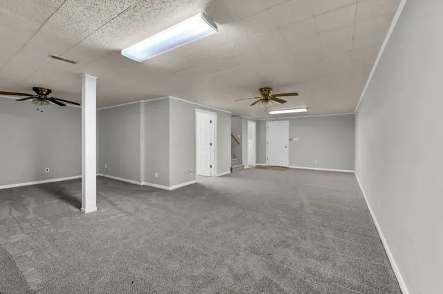 an empty room with a ceiling fan and window