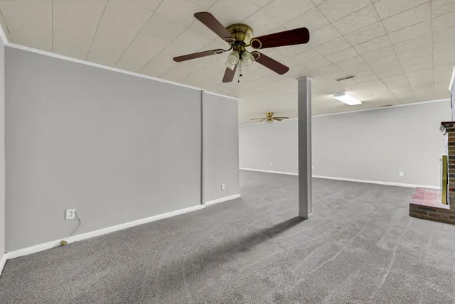 an empty room with a ceiling fan and a window