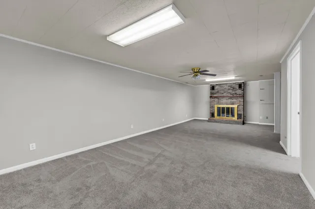 en empty room with windows and fireplace