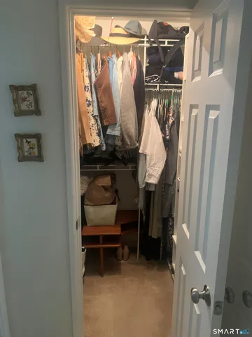 a view of walk in closet with clothes and shoes