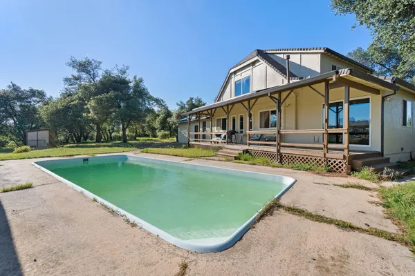 a view of a house with swimming pool and porch