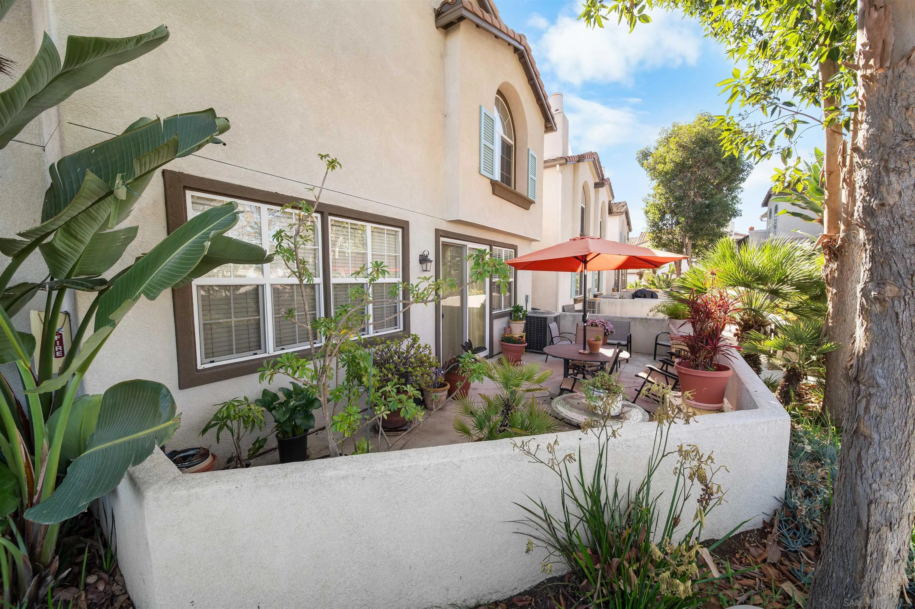 a view of a house with a small yard and potted plants