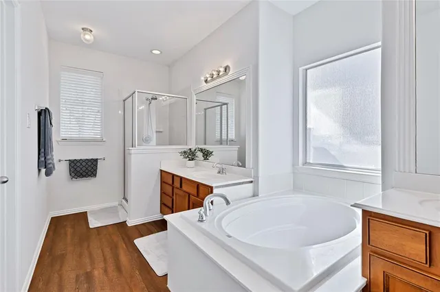 a spacious bathroom with a tub sink and mirror