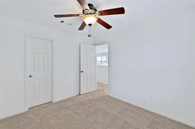 an empty room with chandelier fan