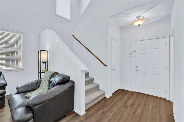a living room with furniture and entryway with wooden floor