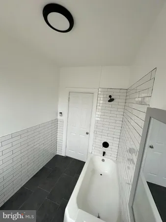 a bathroom with a tub a sink and a shower