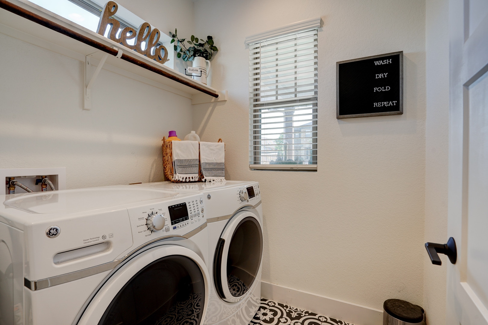 2240 Ringstaff Road Leander, TX 78641 - Photo 20 of 25 Dedicated laundry area featuring a patterned floor, built-in shelving with hanging rod, and a window for natural light