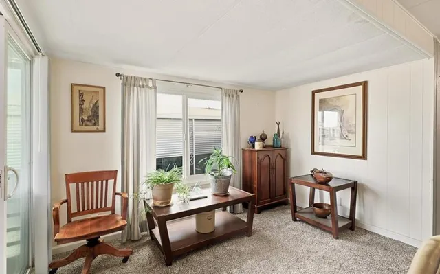 a living room with furniture and a floor to ceiling window