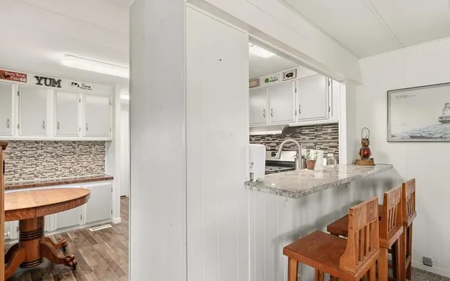 a kitchen with refrigerator a stove a sink and white cabinets