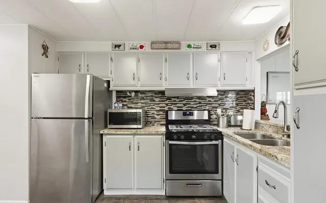 a kitchen with cabinets appliances and a counter space