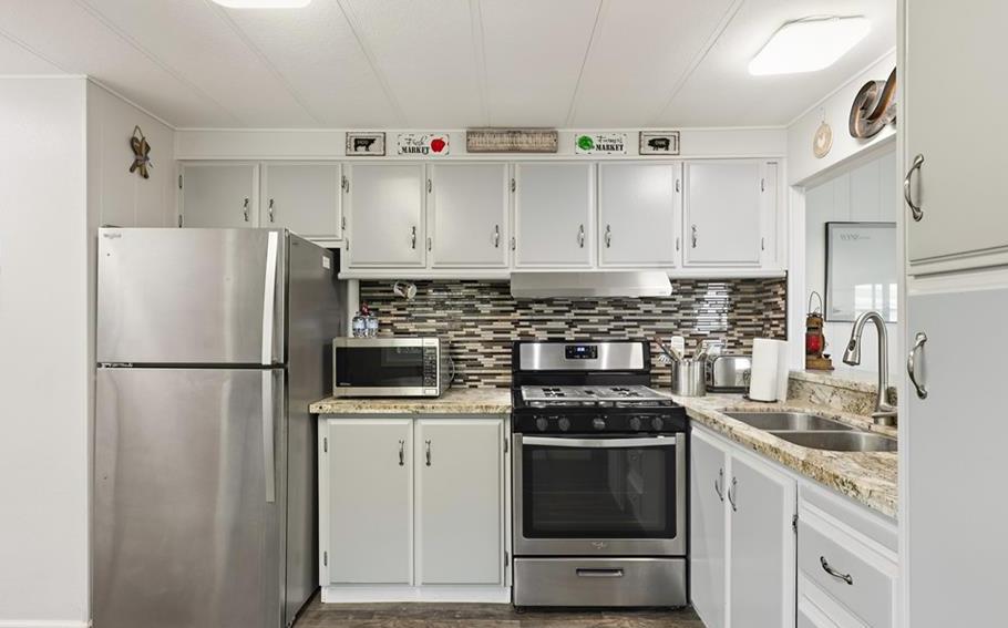 2240 Golden Oak Lane Merced, CA 95340 - Photo 17 of 44 a kitchen with refrigerator a stove a sink and white cabinets