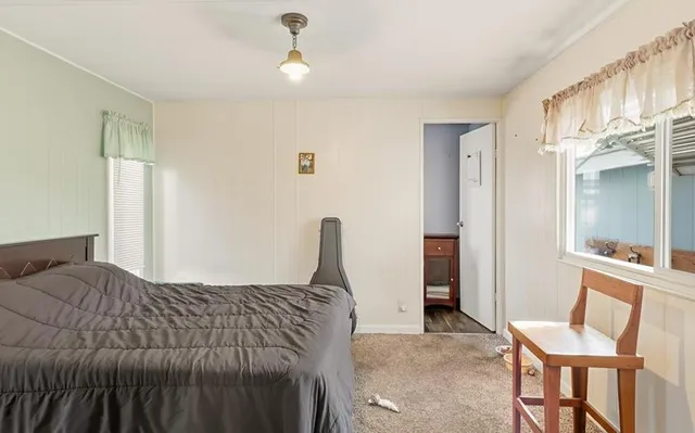 a bed sitting in a bedroom and a chair