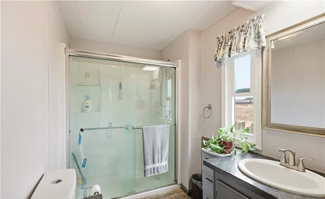 a bathroom with a granite countertop sink toilet and shower