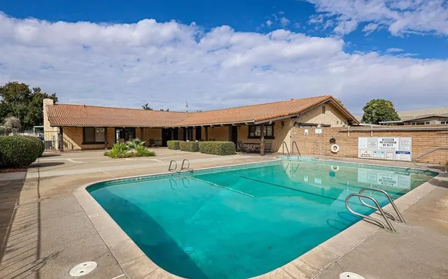 a patio with table and chairs and potted plants