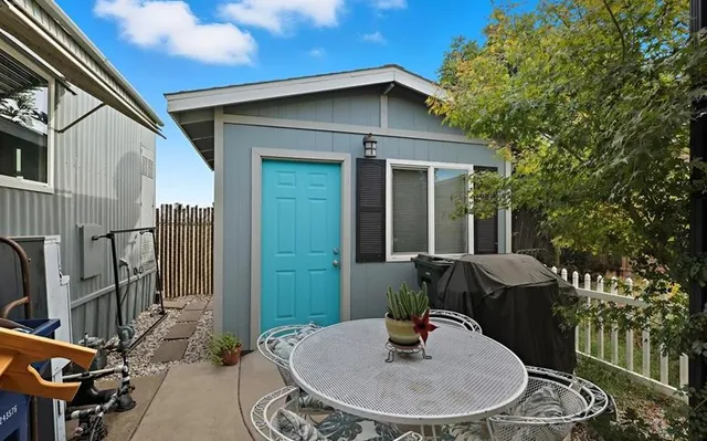 a backyard of a house with table and chairs