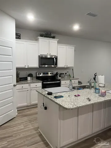 a kitchen with a sink a stove a microwave and cabinets