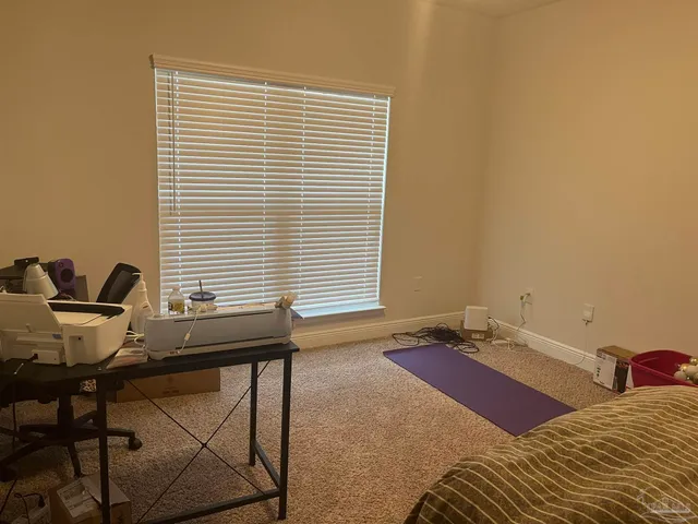 a bedroom with a bed and large windows