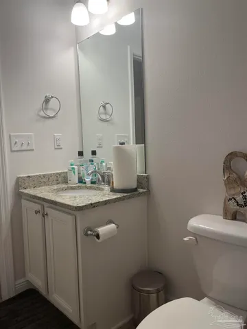 a bathroom with a granite countertop toilet sink and mirror