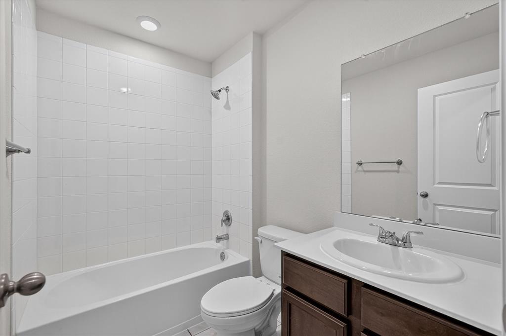 2428 Rosharon Drive Forney, TX 75126 - Photo 17 of 40 Bathroom featuring a white subway tile tub surround, recessed lighting, chrome fixtures, a wood-finish vanity, and a large wall-mounted mirror