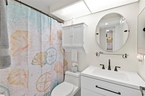 a bathroom with a sink a toilet and mirror