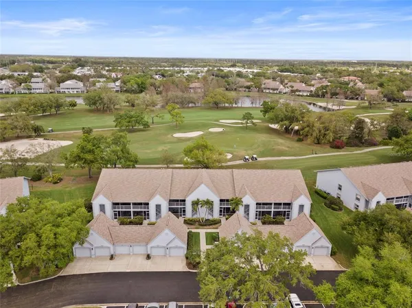 an aerial view of residential houses with outdoor space and ocean view