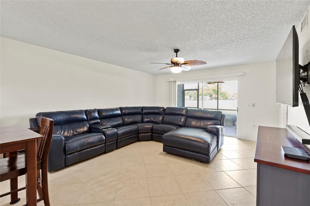 6611 Stone River Road, Unit 102 Bradenton, FL 34203 - Photo 2 of 23 a living room with furniture and a flat screen tv