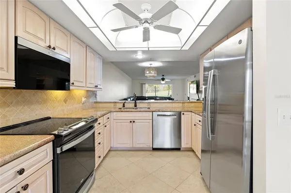 a kitchen with stainless steel appliances granite countertop a sink a stove and a refrigerator