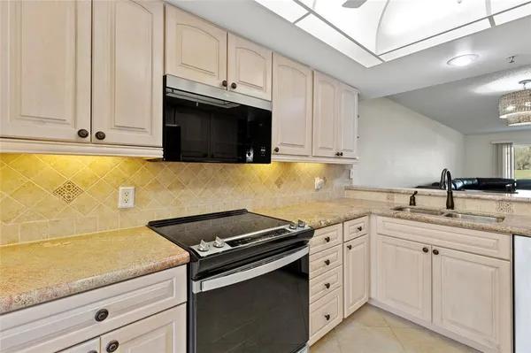 a kitchen with stainless steel appliances granite countertop white cabinets a sink and dishwasher