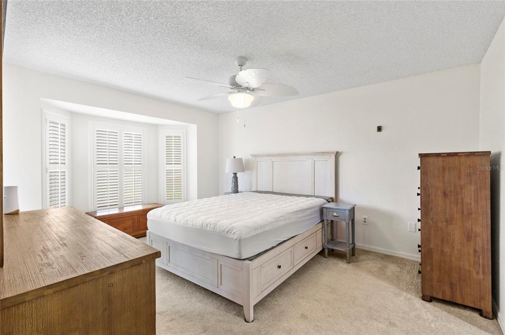 6611 Stone River Road, Unit 102 Bradenton, FL 34203 - Photo 8 of 23 a bedroom with a bed and a chandelier