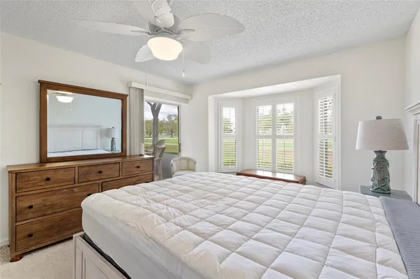 a bedroom with a large bed and a flat tv screen on dresser