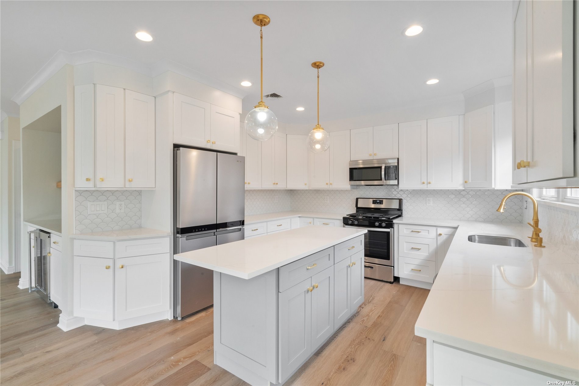 a kitchen with kitchen island a white counter top space cabinets and stainless steel appliances