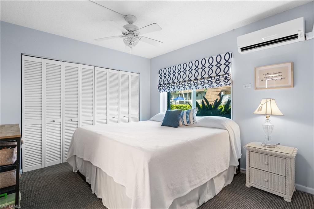 87 North Collier Boulevard, Unit B4 Marco Island, FL 34145 - Photo 12 of 31 a bedroom with a bed and a chandelier