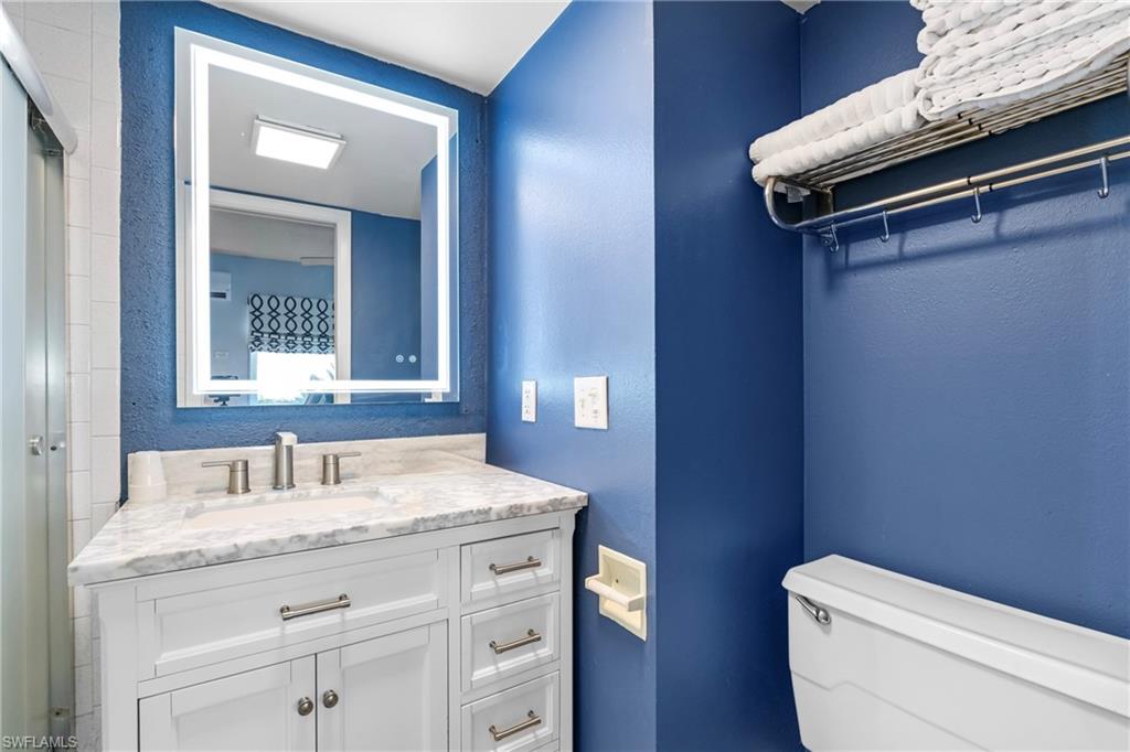 87 North Collier Boulevard, Unit B4 Marco Island, FL 34145 - Photo 15 of 31 a bathroom with a granite countertop toilet sink and mirror
