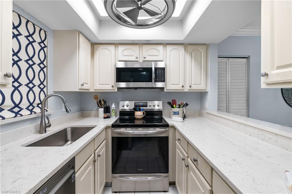 87 North Collier Boulevard, Unit B4 Marco Island, FL 34145 - Photo 7 of 31 a kitchen with a sink stove and microwave