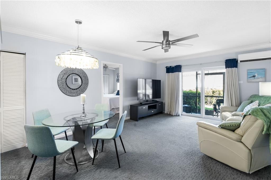 87 North Collier Boulevard, Unit B4 Marco Island, FL 34145 - Photo 9 of 31 a living room with furniture a clock and a chandelier