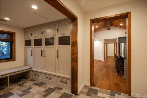 a view of an empty room with wooden floor and a fireplace