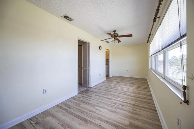a view of a livingroom with wooden floor and a ceiling fan