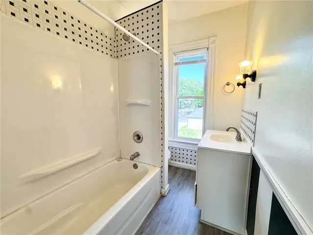 a bathroom with a tub a sink and a large mirror