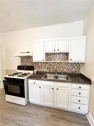 a kitchen with granite countertop a sink and a stove