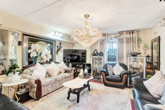 a living room with furniture chandelier and a flat screen tv