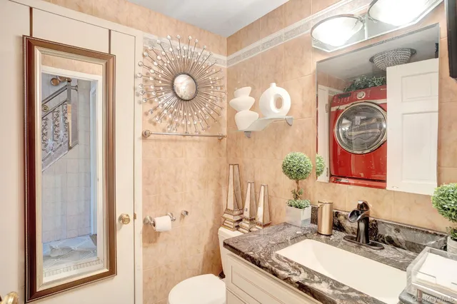 a bathroom with a granite countertop sink mirror vanity and toilet