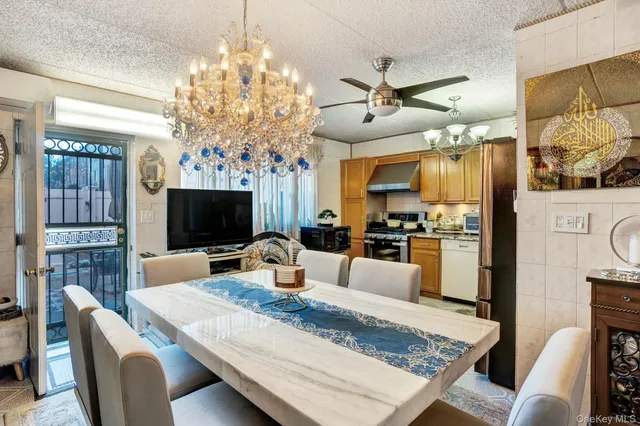 a view of a dining room with furniture a chandelier and wooden floor