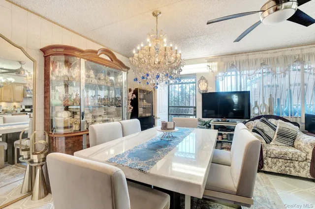 a living room with furniture a flat screen tv and a chandelier