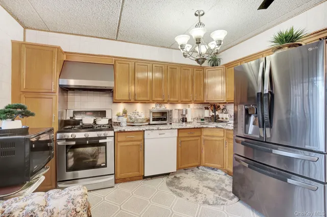 a kitchen with stainless steel appliances granite countertop a refrigerator a stove a sink and dishwasher