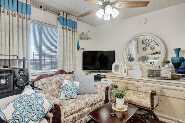 a living room with furniture a flat screen tv and a large window