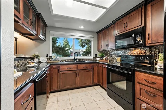 a kitchen with stainless steel appliances granite countertop a sink and stove top oven
