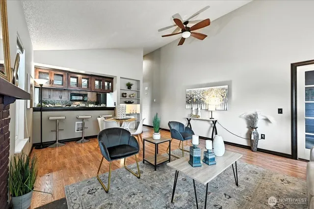 a living room with furniture kitchen view and a window