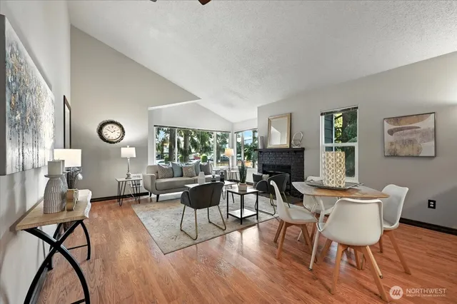 a living room with furniture a fireplace and a large window