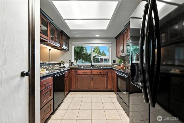 a kitchen with stainless steel appliances granite countertop a refrigerator a sink a stove and cabinets